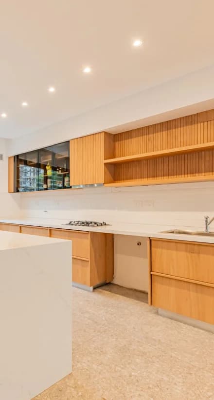 Cocina con isla blanca con combinación de muebles azules y marrones